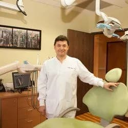 Dr. Leon Vilner standing beside a dental chair